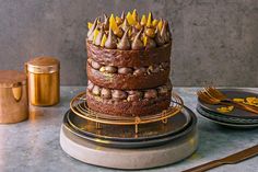 a chocolate cake sitting on top of a table next to plates and utensils