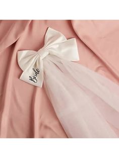 a pink dress with a white bow and name on it