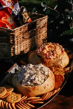 two breads and crackers are sitting on a table with snacks in the basket