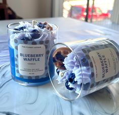 two blueberry waffles are sitting next to each other on a white table