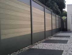 a long row of wooden slats next to a building with a fence on the side