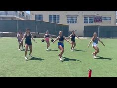 a group of young women playing a game of frisbee on top of a field