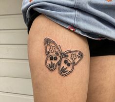 a woman's thigh with a butterfly tattoo on the back of her leg,