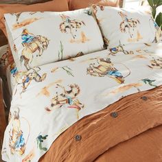 the comforter is made up with an image of a cowboy riding a horse