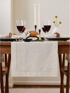 the table is set with wine glasses and bread