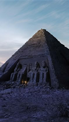 an ancient egyptian pyramid in the desert at dusk with two people standing next to it