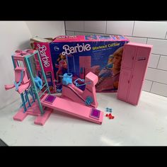 a pink barbie doll house and accessories on a counter with the box opened to reveal it's contents