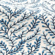 a blue and white fabric with small leaves on the top of it's surface