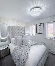 a bedroom with a large bed and chandelier