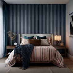 a bedroom with blue walls and striped bedding