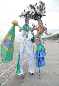 two women dressed in colorful costumes standing next to each other on the side of a road