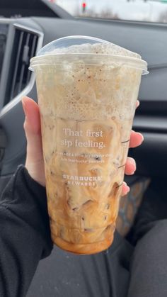 a person holding up a drink in their hand with the words that first sip feeling on it