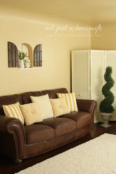 a living room with couches, rugs and potted plants on the wall