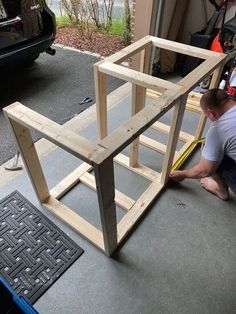 a man is building a house out of plywood and some glue on the floor