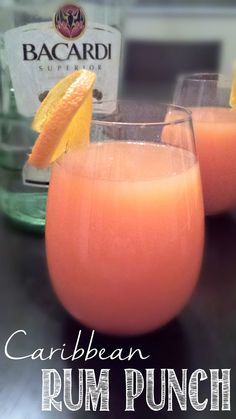 the rum punch is garnished with an orange slice