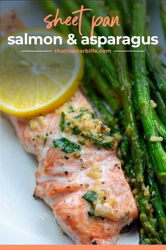 salmon and asparagus on a white plate with lemon wedged garnish