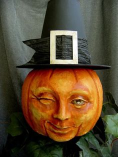 a carved pumpkin with a black hat on top