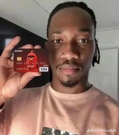 a man holding up a credit card in front of his face