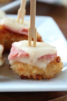 some food is on a white plate with toothpicks sticking out of the top