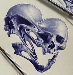 two drawings of skulls on paper with paintbrushes