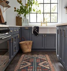 a kitchen with gray cabinets and rug in the middle