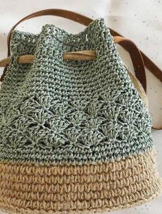 a crocheted handbag sitting on top of a bed