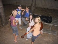 a group of young people standing next to each other in front of a bbq