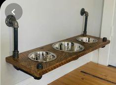 two metal bowls sitting on top of a wooden shelf