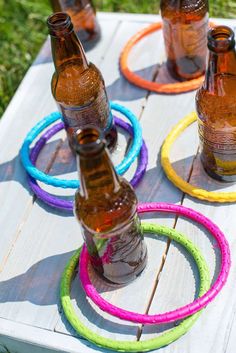 several empty beer bottles sitting on top of a wooden table with colorful rings around them