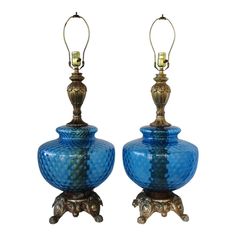 a pair of blue glass lamps sitting next to each other