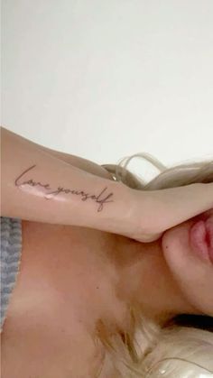 a woman with a tattoo on her arm that reads, love is everything you want