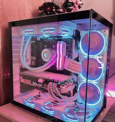 the inside of a computer case that is lit up with blue and pink lights on it