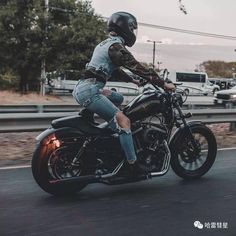 a man riding on the back of a motorcycle down a street next to a highway