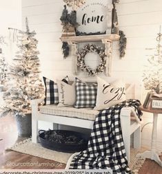 a living room filled with furniture and christmas decorations on the wall above it is a white couch covered in black and white plaid throw pillows