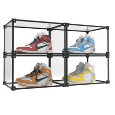 four pairs of sneakers are in a glass case on the wall, each with different colors and sizes