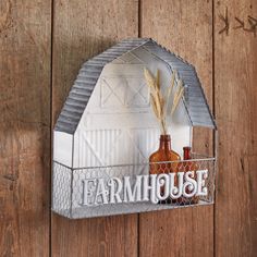 a farm house sign hanging on the side of a wooden wall next to two bottles