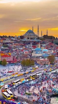 an aerial view of a city with lots of traffic and people walking around it at sunset