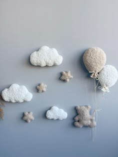 the wall is decorated with clouds, teddy bears and a hot air balloon hanging from it's side