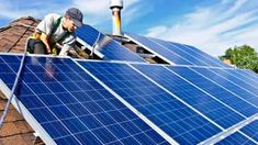 a man on top of a roof installing solar panels