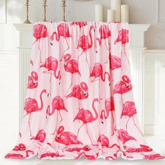 a pink flamingo print window curtain hanging on a white wall next to a fireplace