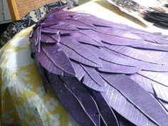 a large purple bird sitting on top of a bed