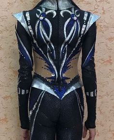 the back of a woman's black and silver bodysuit with blue accents on it