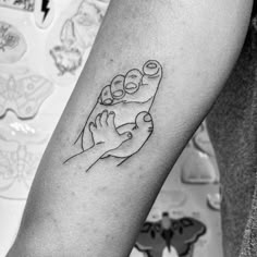 a black and white photo of a person's arm with a tattoo on it