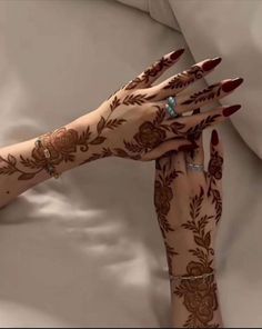 two hands with henna tattoos on them