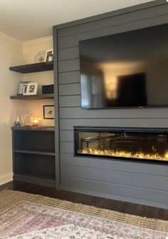 a flat screen tv mounted to the side of a wall next to a fire place