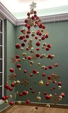 a christmas tree made out of red and gold ornaments hanging from it's ceiling