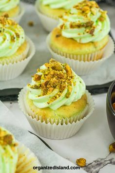 cupcakes with green frosting and nuts on top