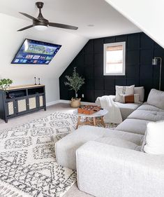 a living room filled with furniture and a flat screen tv mounted to the side of a wall