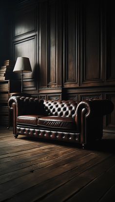 a brown leather couch sitting on top of a wooden floor next to a book shelf