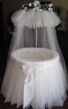 a white chair with a veil over it and flowers on the back of it's seat